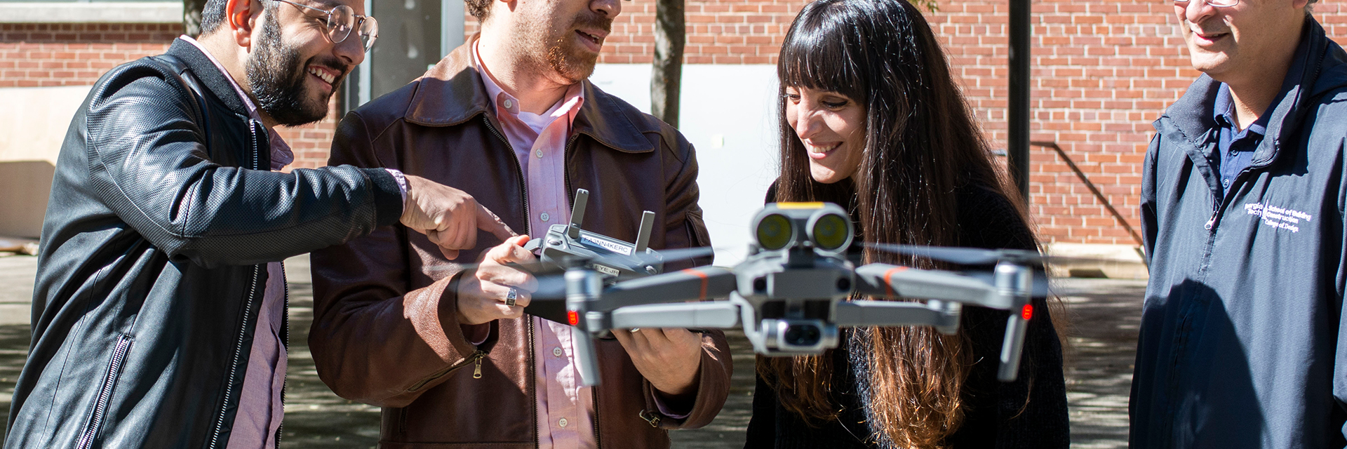 Ph.D. researchers and assistant professor, Tarek Rakha, flying a drone in the Hinman Courtyard. 