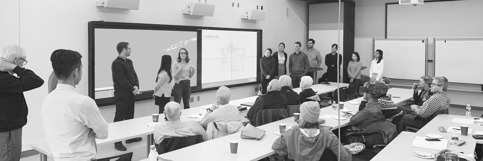 Students stand in front of community members in the John and Joyce Caddell Building Flex Space for their final presentations for the Flourishing Communities Collaborative.
