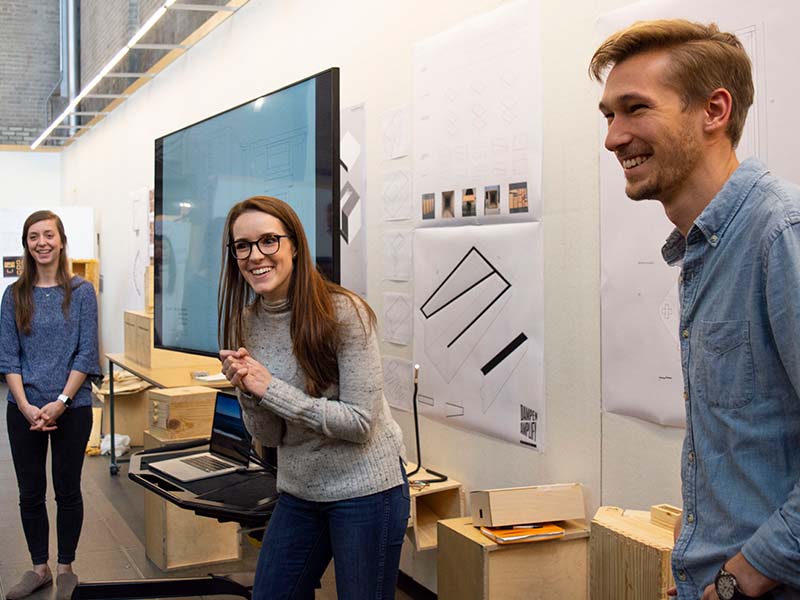 Students laughing as they present a Portman Studio project in the Hinman Research Building