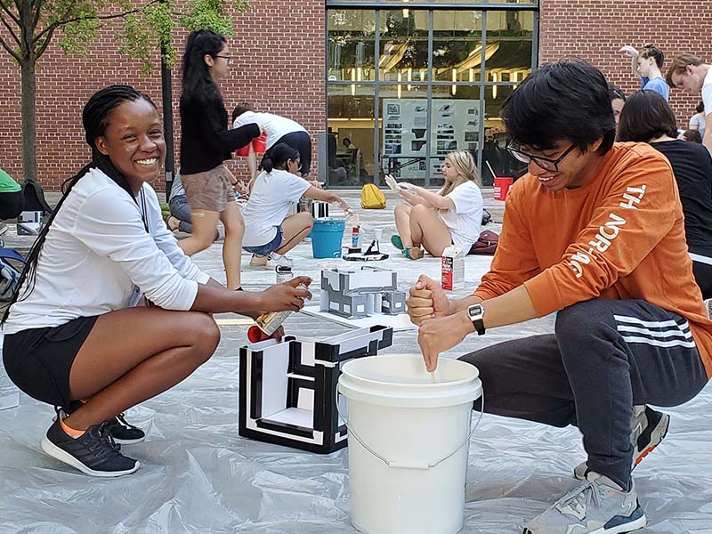 Students make models by pouring concrete in the Hinman Courtyard