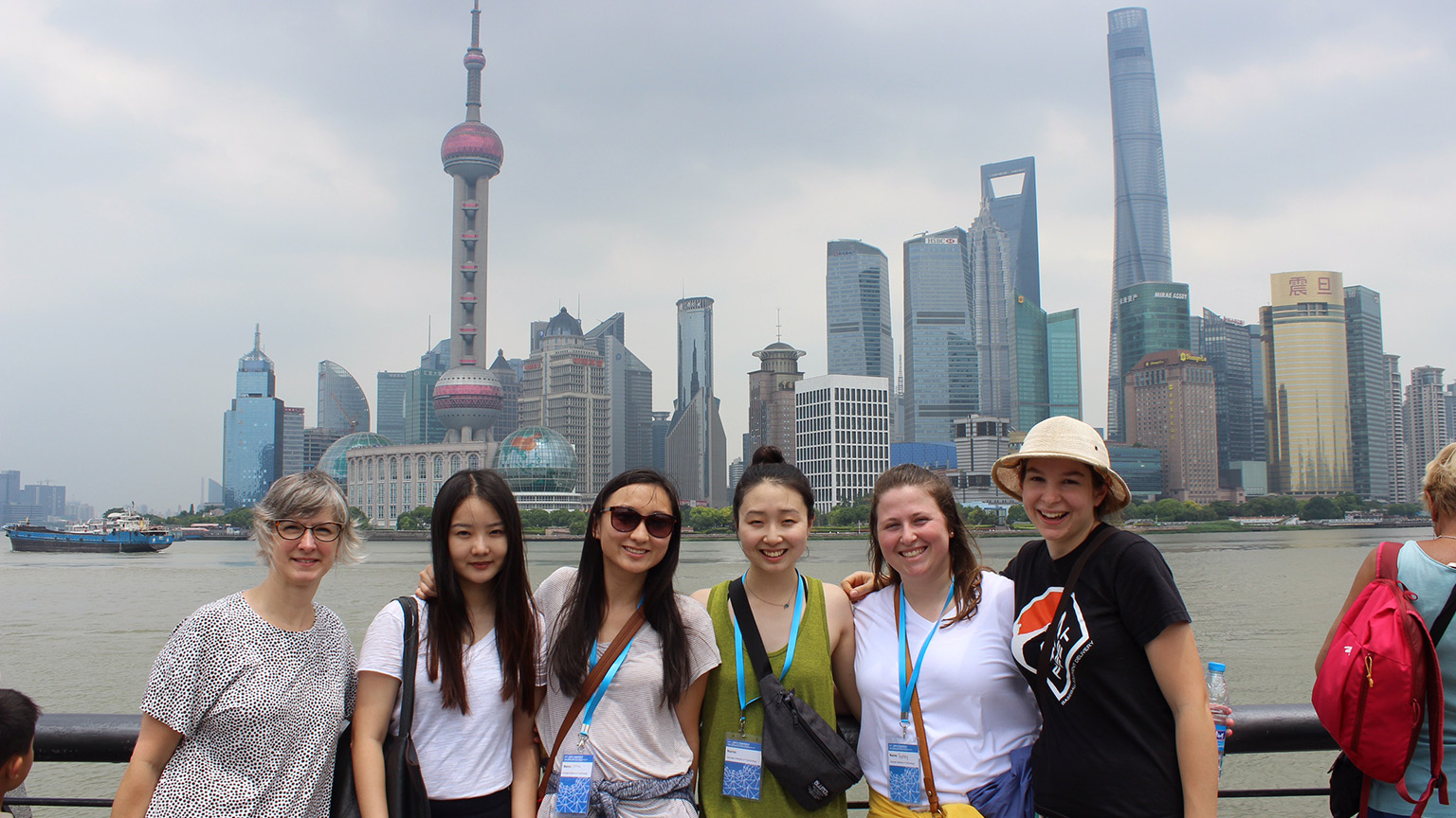 Michelle Rinehart and students stand in front of the Shanghai skyline 