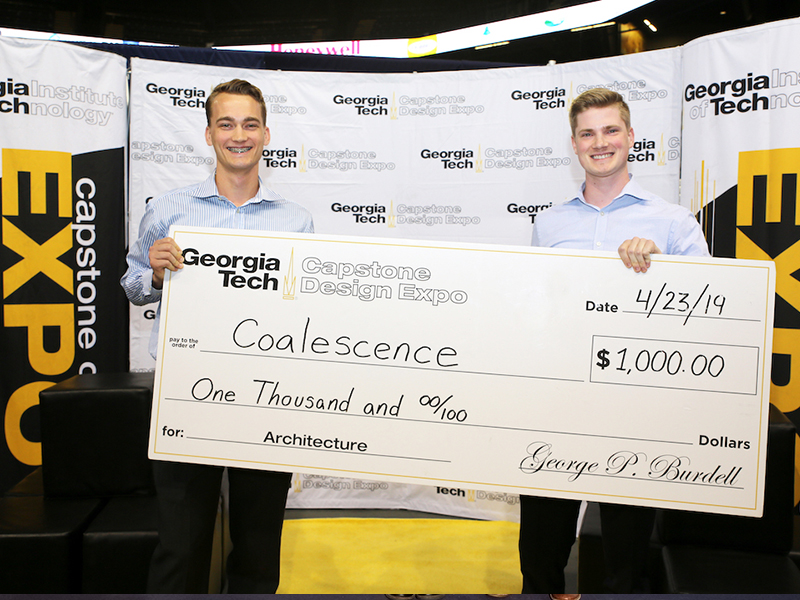 Christopher Tromp and Noah Sannes with their winning check at the Capstone Design Competition.