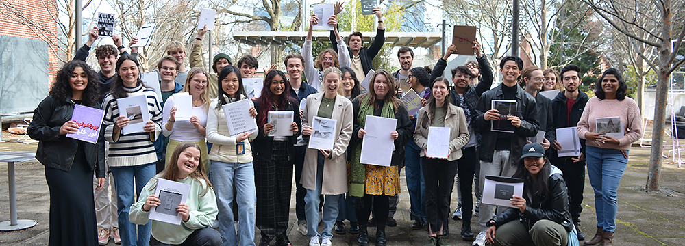 Architecture students gather in the Hinman Courtyard holding their portfolios.