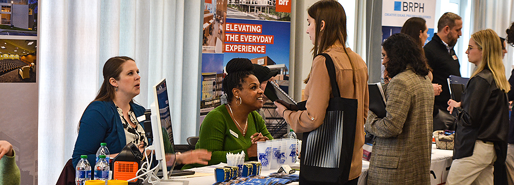 Students speak with industry representatives during a job fair.