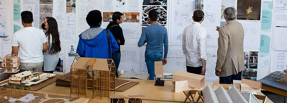 Students and professors critique pinned up architecture work.